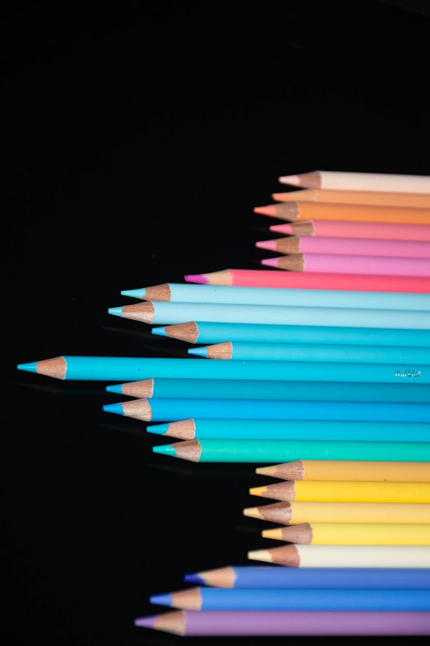A vibrant array of colored pencils on a black background, ideal for art and design projects.