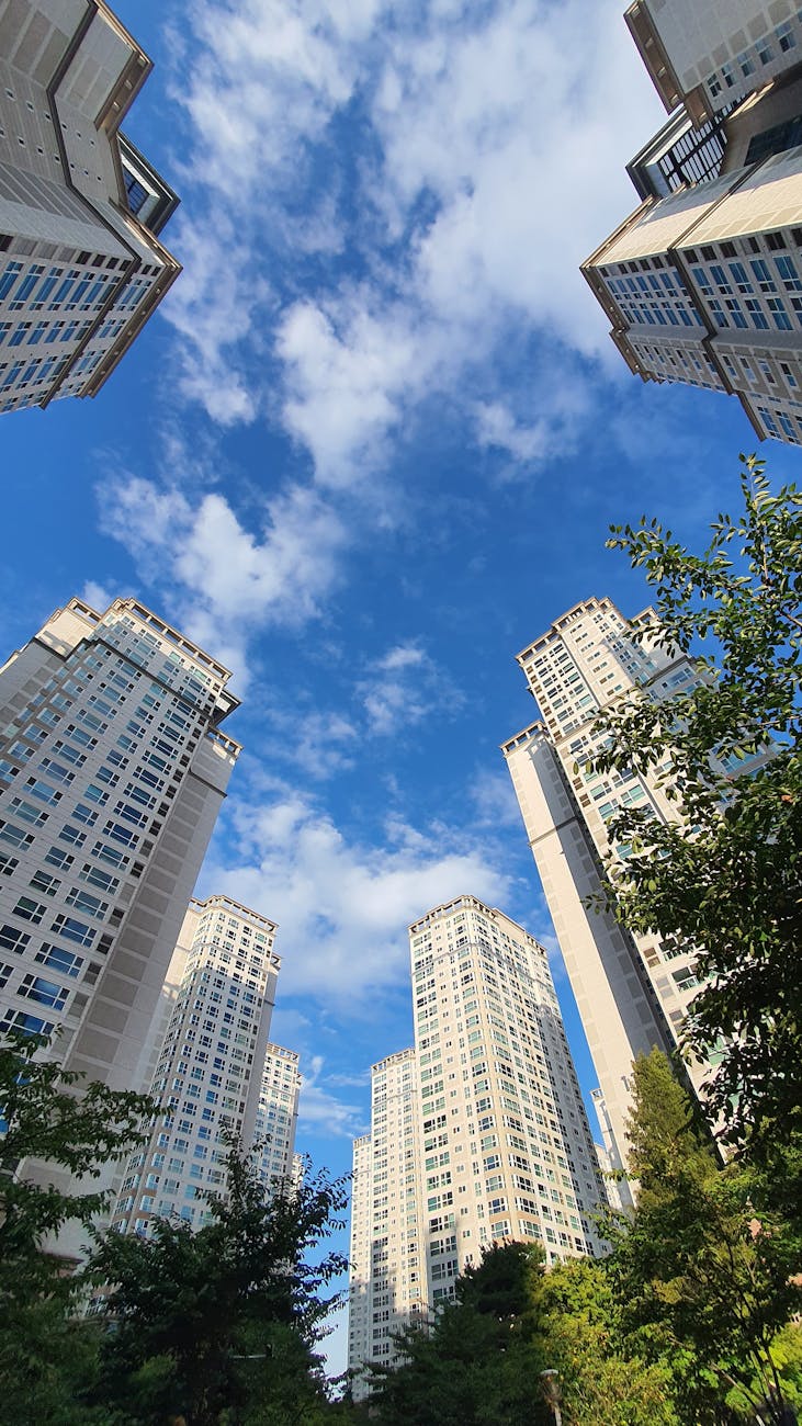 Modern skyscrapers in Seoul reaching towards a vibrant blue sky, showcasing urban architecture.