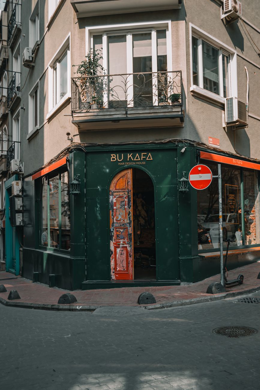 A quaint café at a street corner in an urban setting, showcasing unique architecture.