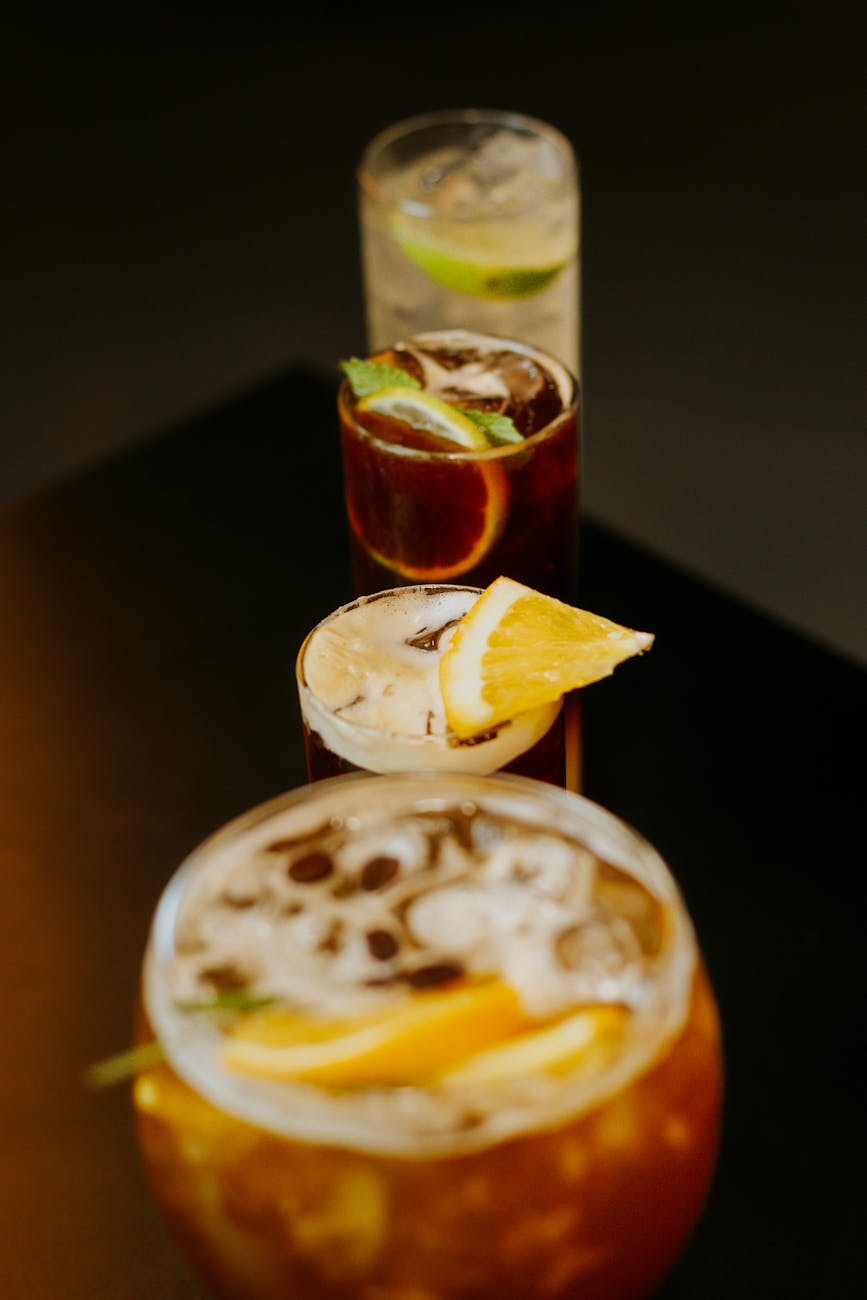 An artistic display of various citrus cocktails with fresh fruit garnishes, perfect for a summer refreshment.