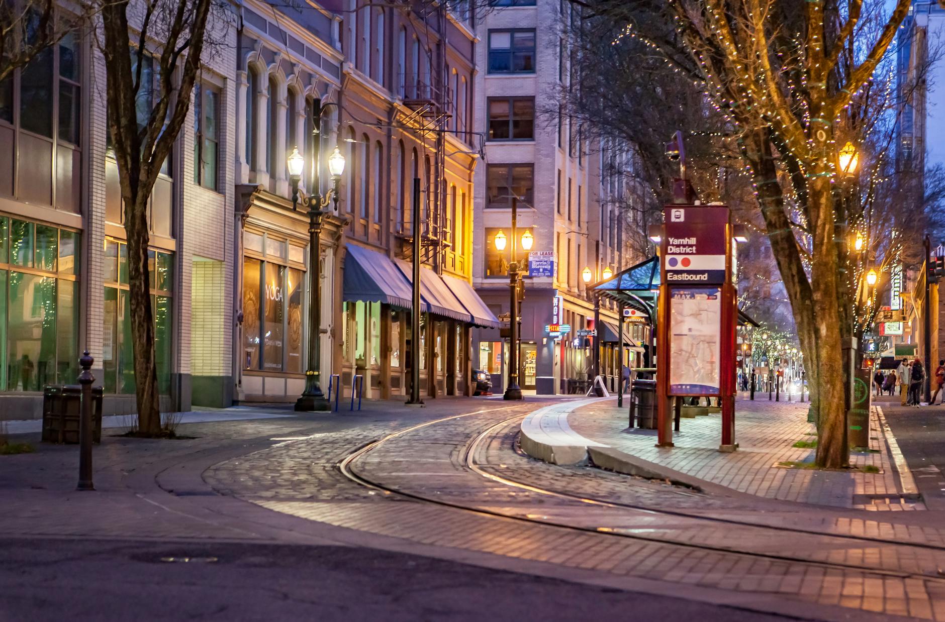 Charming evening view of Yamhill District street in Portland, OR, with streetlights and urban architecture.