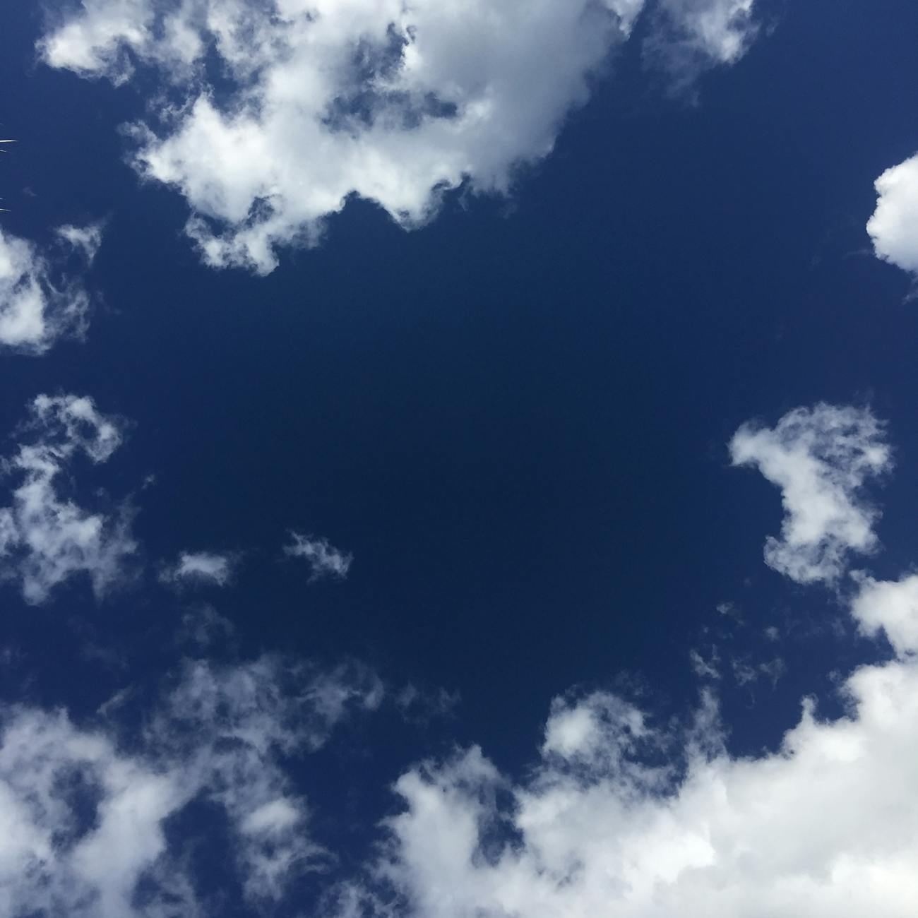 A stunning view of a deep blue sky filled with wispy white clouds on a sunny day.
