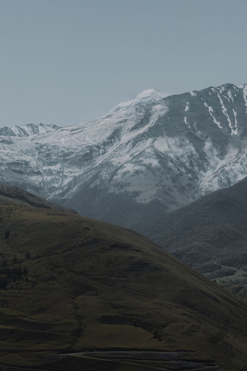 Majestic snow-covered mountains under a serene sky in North Ossetia, Russia.