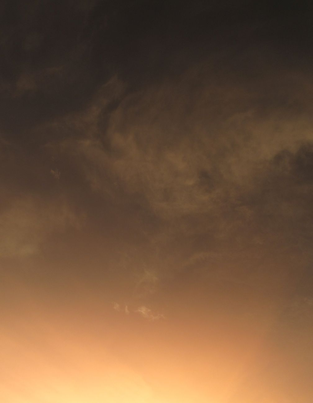 A serene sunset sky with dramatic cloud formations, casting warm hues across the horizon.