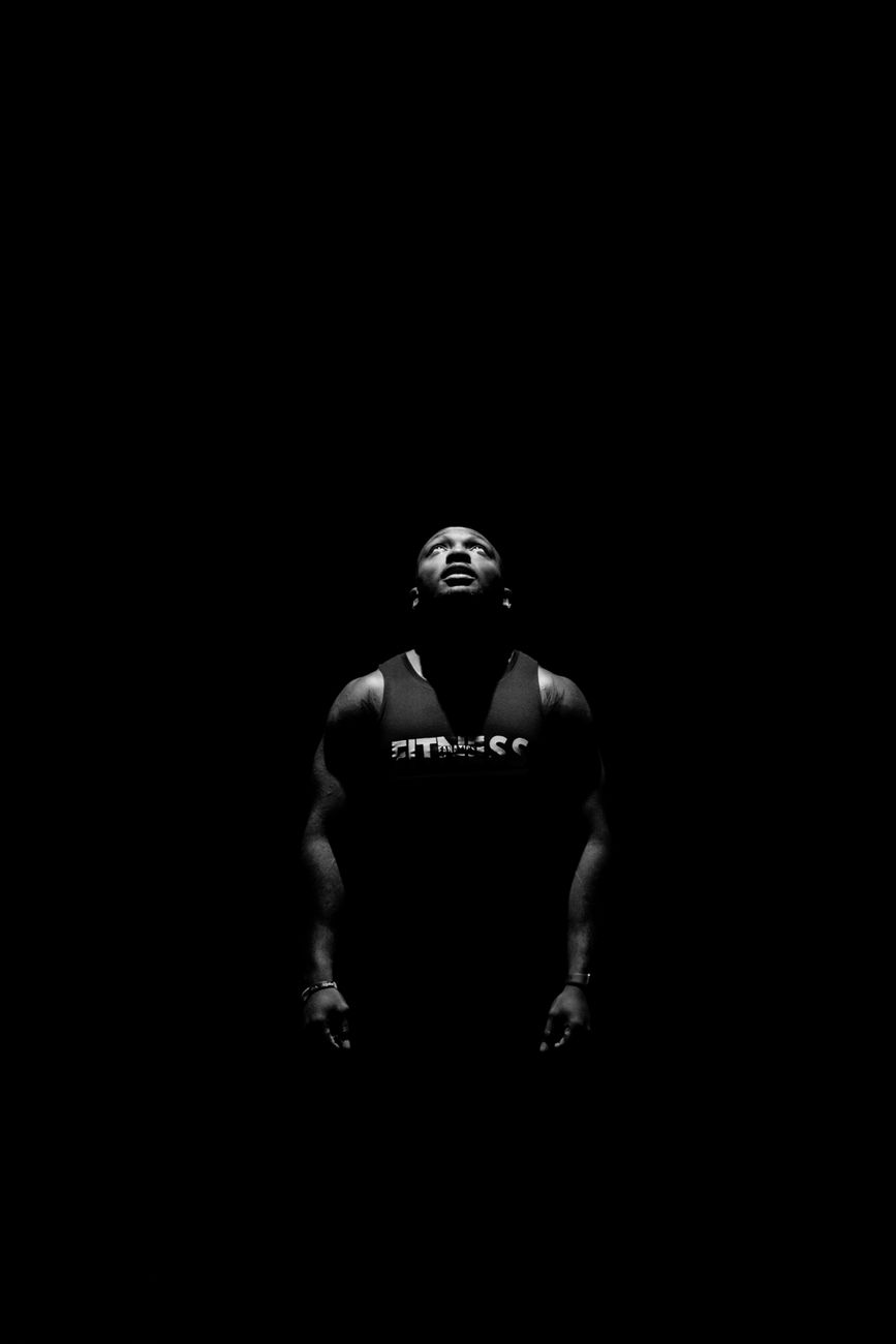 Powerful black and white portrait of a man gazing upwards, capturing strength and focus.