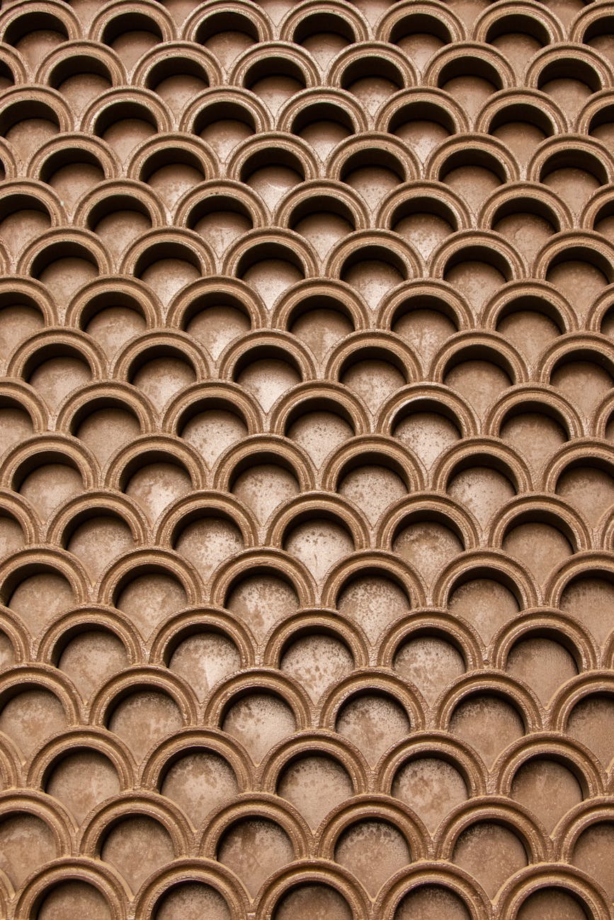 Intricate brown geometric pattern creating an abstract wallpaper texture.