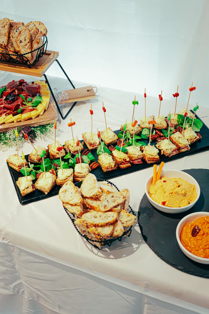 Delicious assortment of sandwiches and dips on a buffet table, perfect for events.
