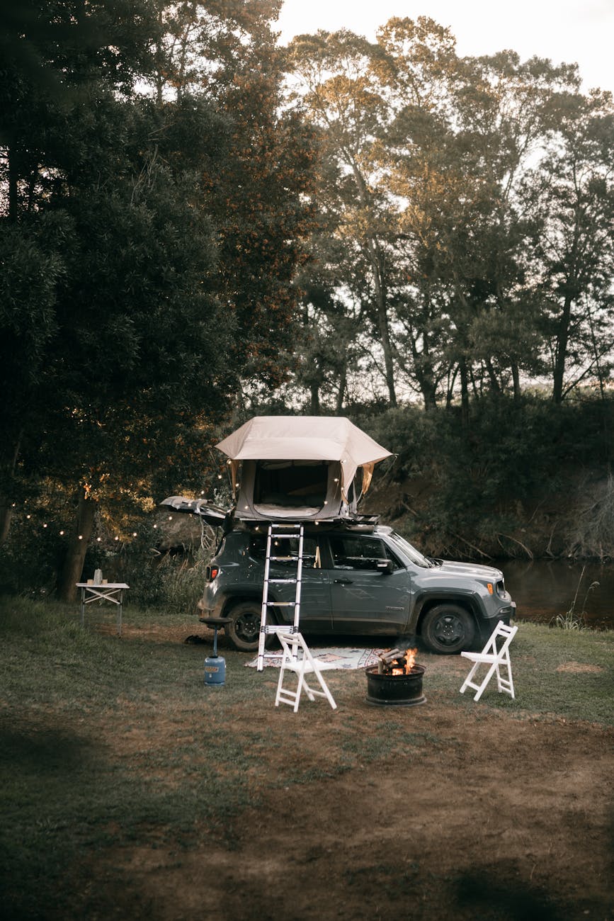 Explore the outdoors with a cozy car campsite beside a river.