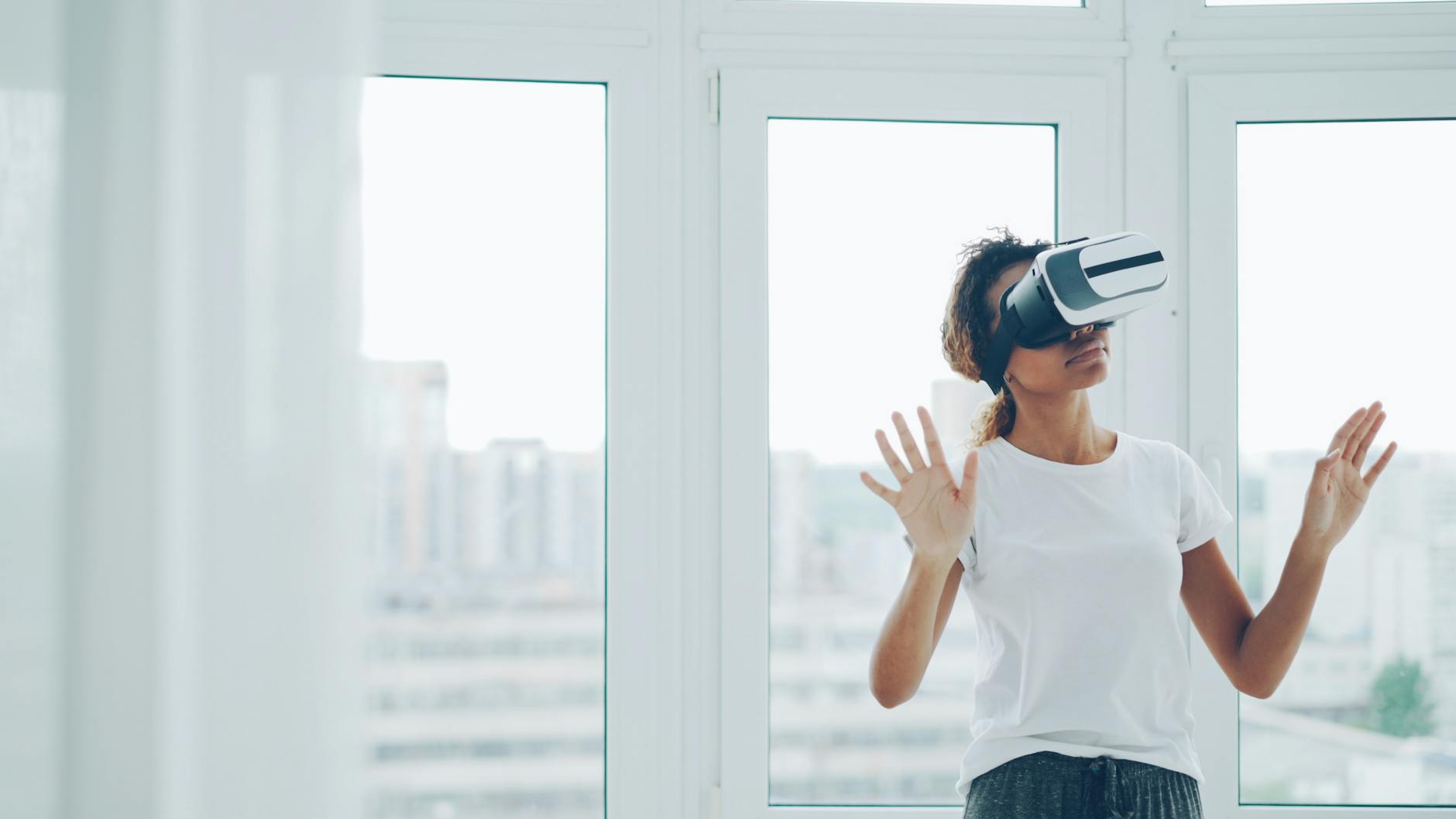 A woman enjoying a virtual reality experience with VR headset indoors.