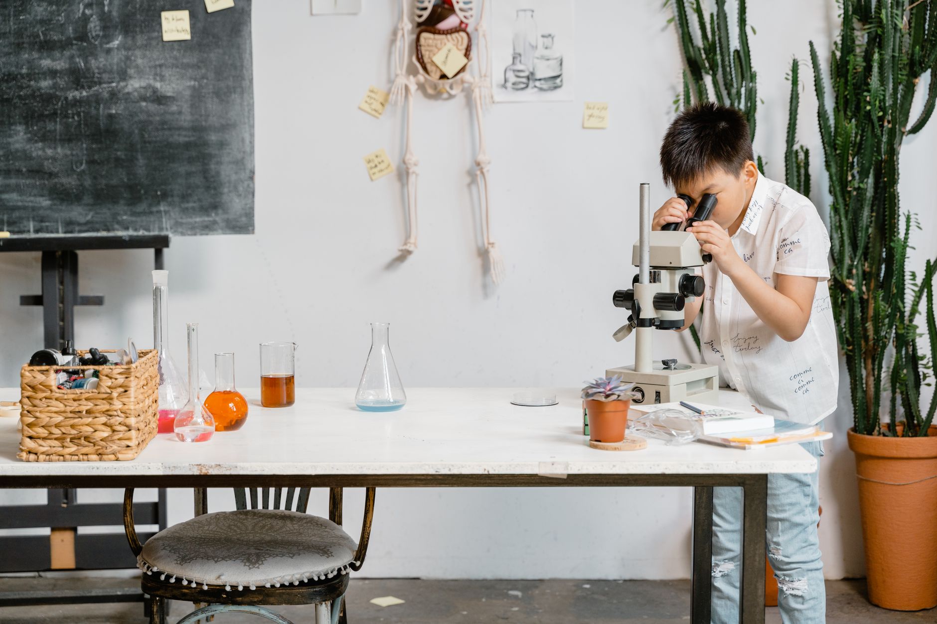 A young boy in a laboratory examining samples through a microscope for educational purposes.