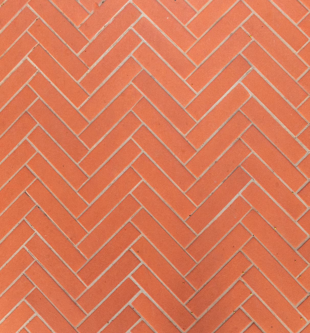 Close-up of a herringbone patterned red brick wall, perfect for backgrounds or textures.