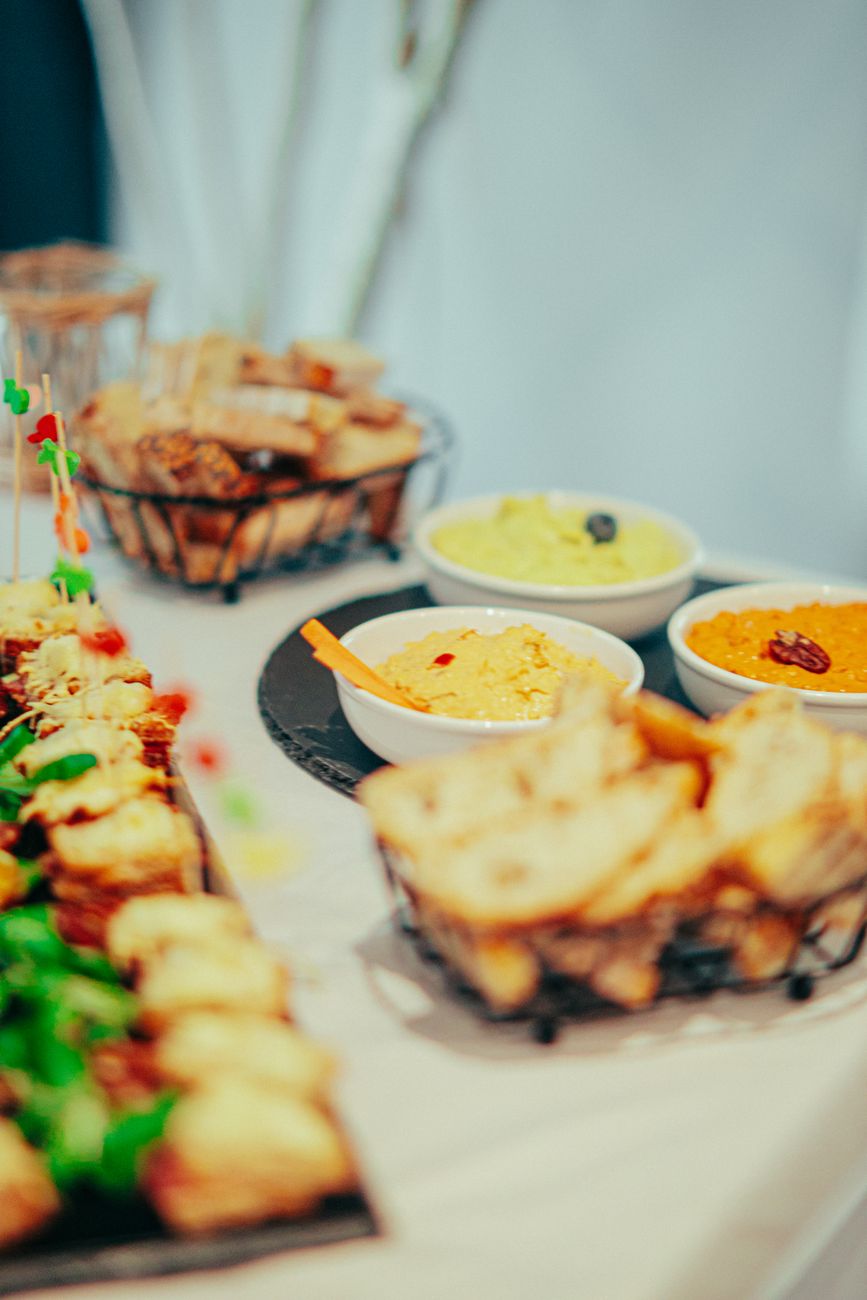 Close-up of a buffet table featuring dips, bread, and appetizers, offering a delicious culinary experience.