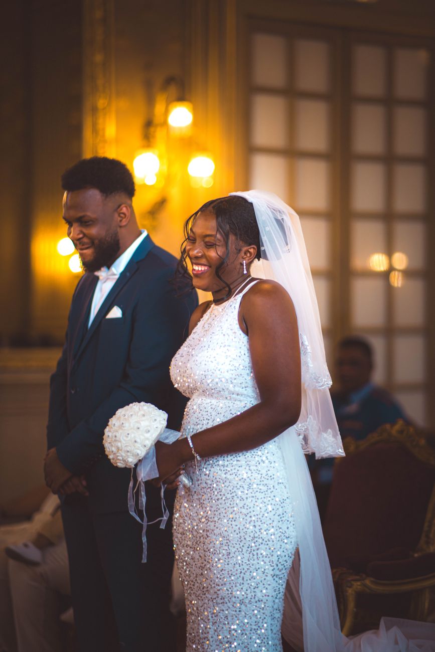 A joyful moment captured during a beautiful wedding ceremony indoors with a smiling couple.