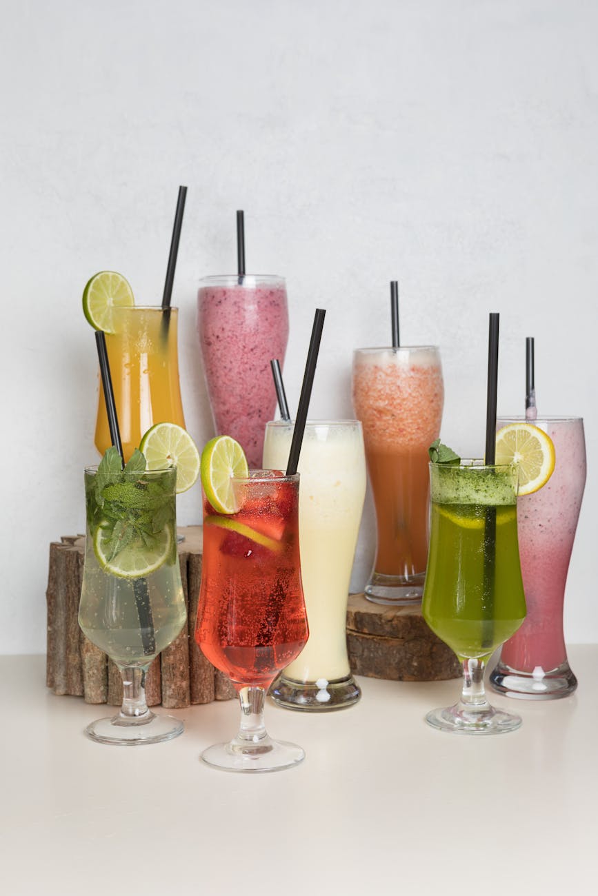 Colorful array of fresh fruit cocktails in assorted glasses with garnishes.