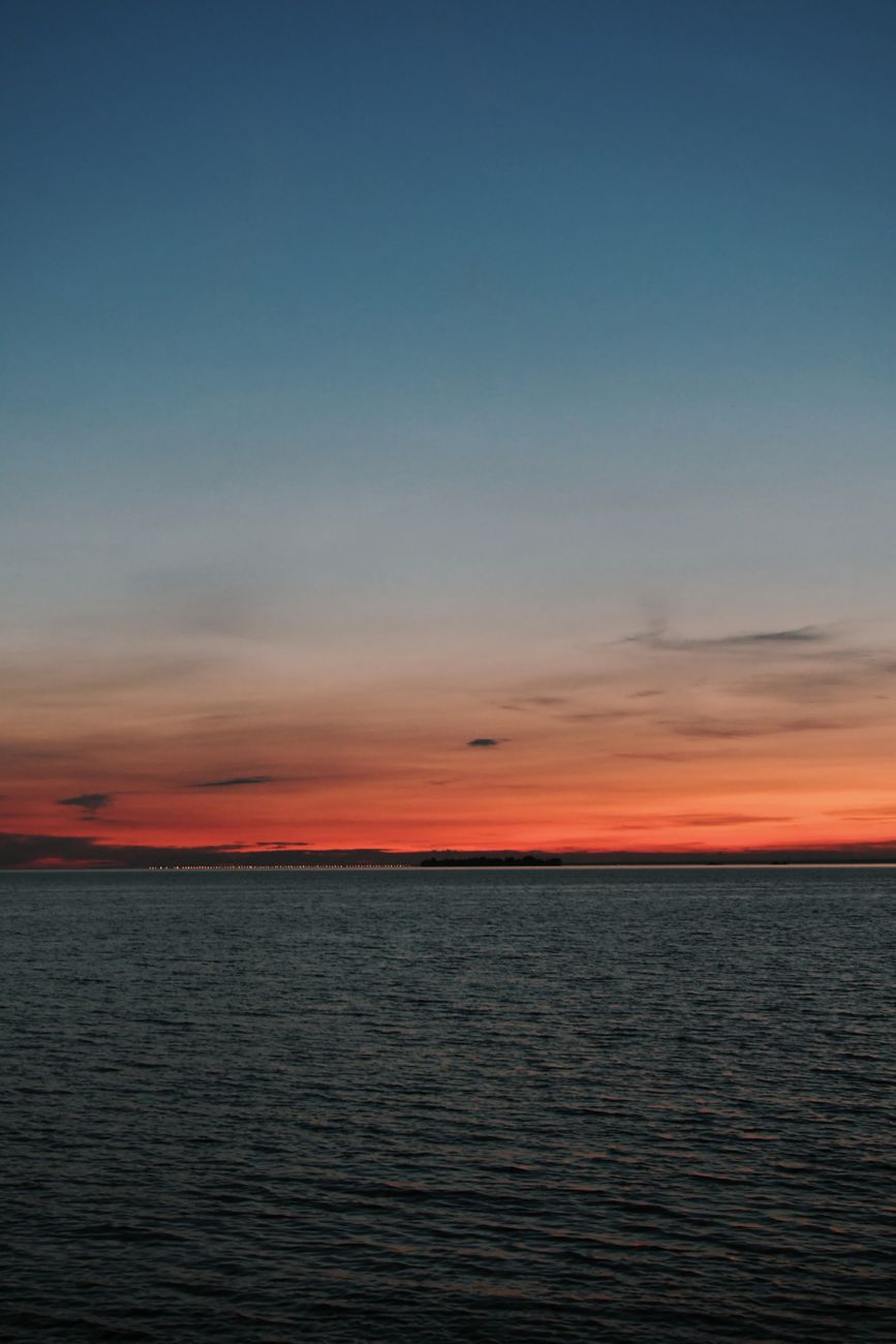Stunning sunset over a calm ocean, capturing vibrant hues and peaceful reflections.