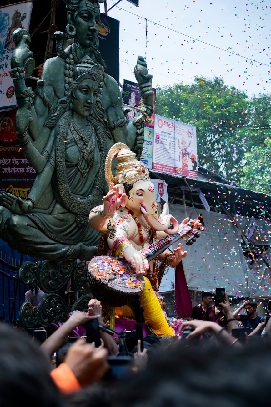 Colorful Ganesh Chaturthi festival with ornate statues and lively crowds in Mumbai streets.