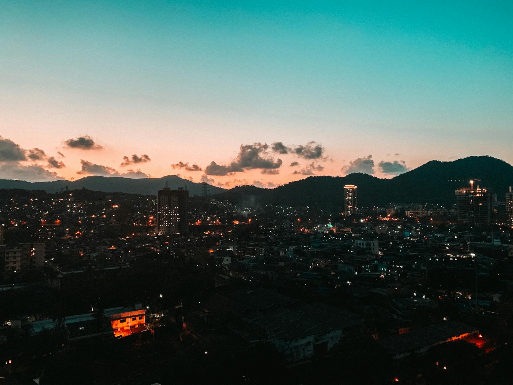 A captivating cityscape at twilight with glowing lights against a serene sunset sky.