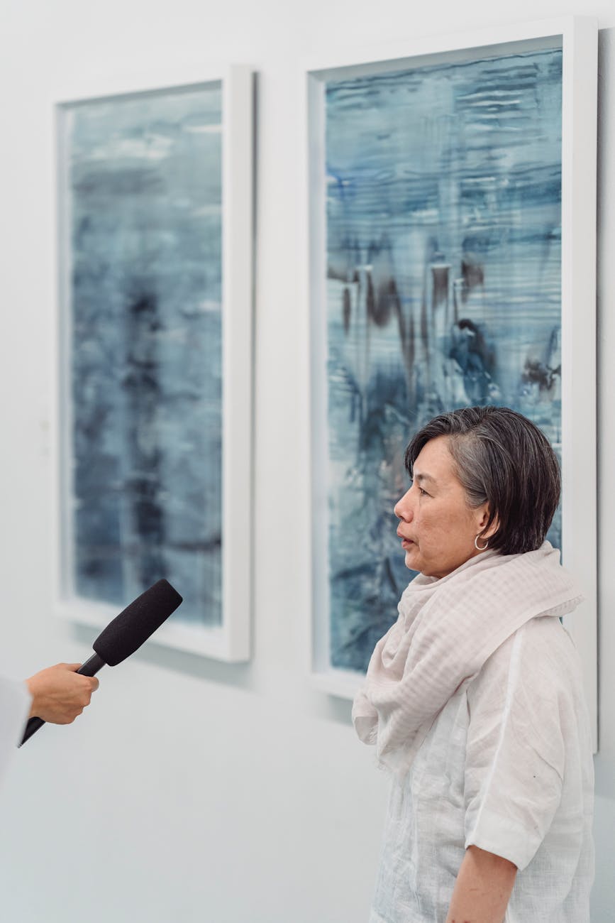 Artist discusses their work in an art gallery interview.