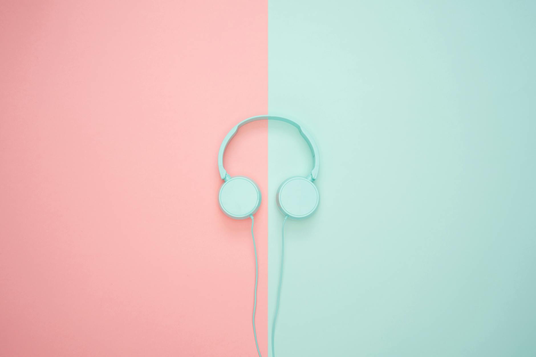 Minimalist headphones on a pink and mint background, artistic and modern.