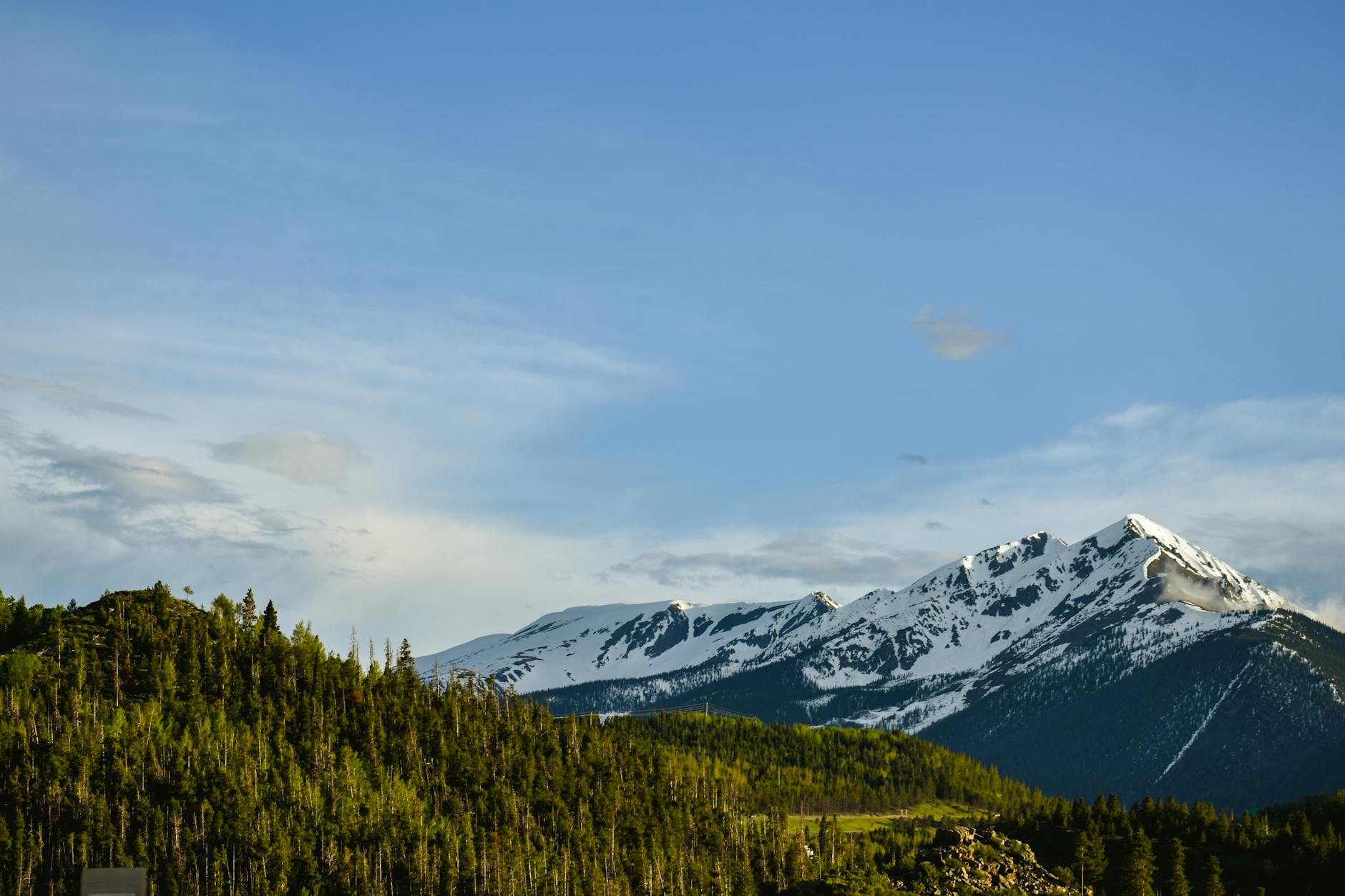 Scenic view of snow-capped peaks in Colorado's Rocky Mountains under a clear blue sky.