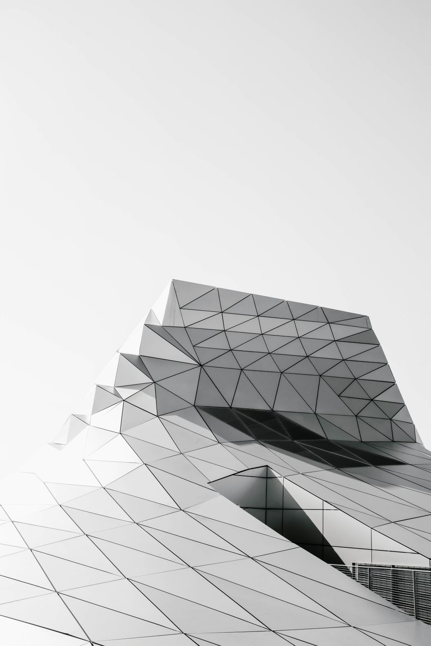 Black and white photo of a modern geometric building with a futuristic design.