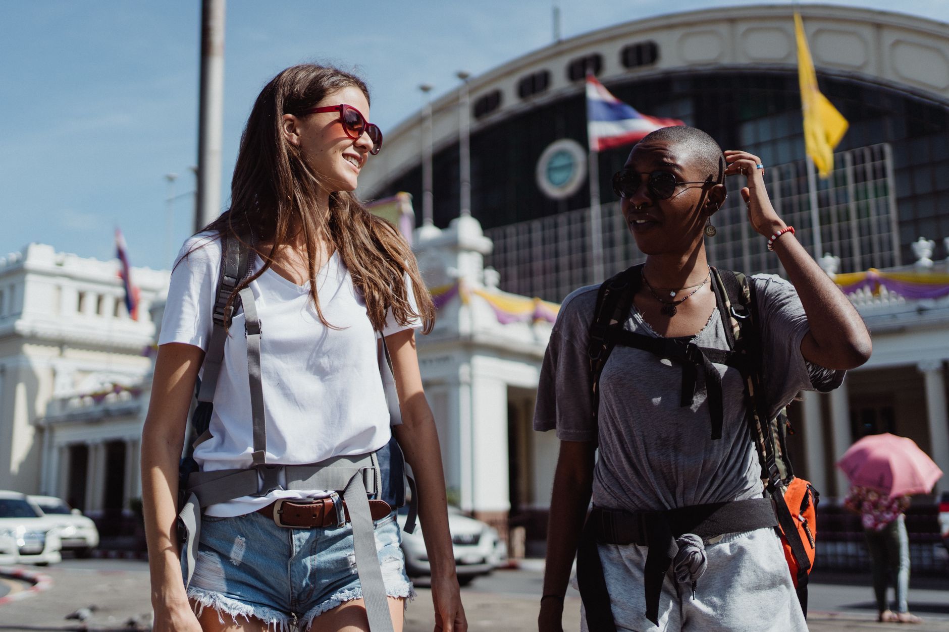 Two women travelers enjoying a sunny day exploring a new city.