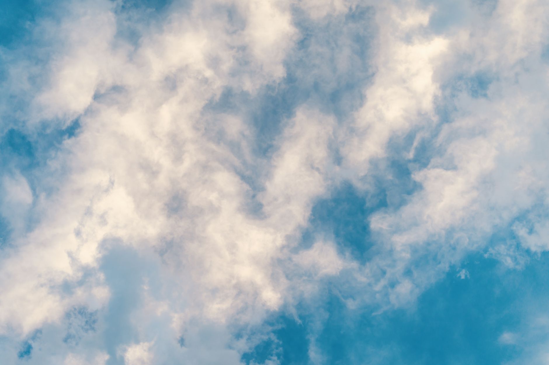 A serene view of fluffy clouds against a bright blue sky, perfect for peaceful and airy concepts.