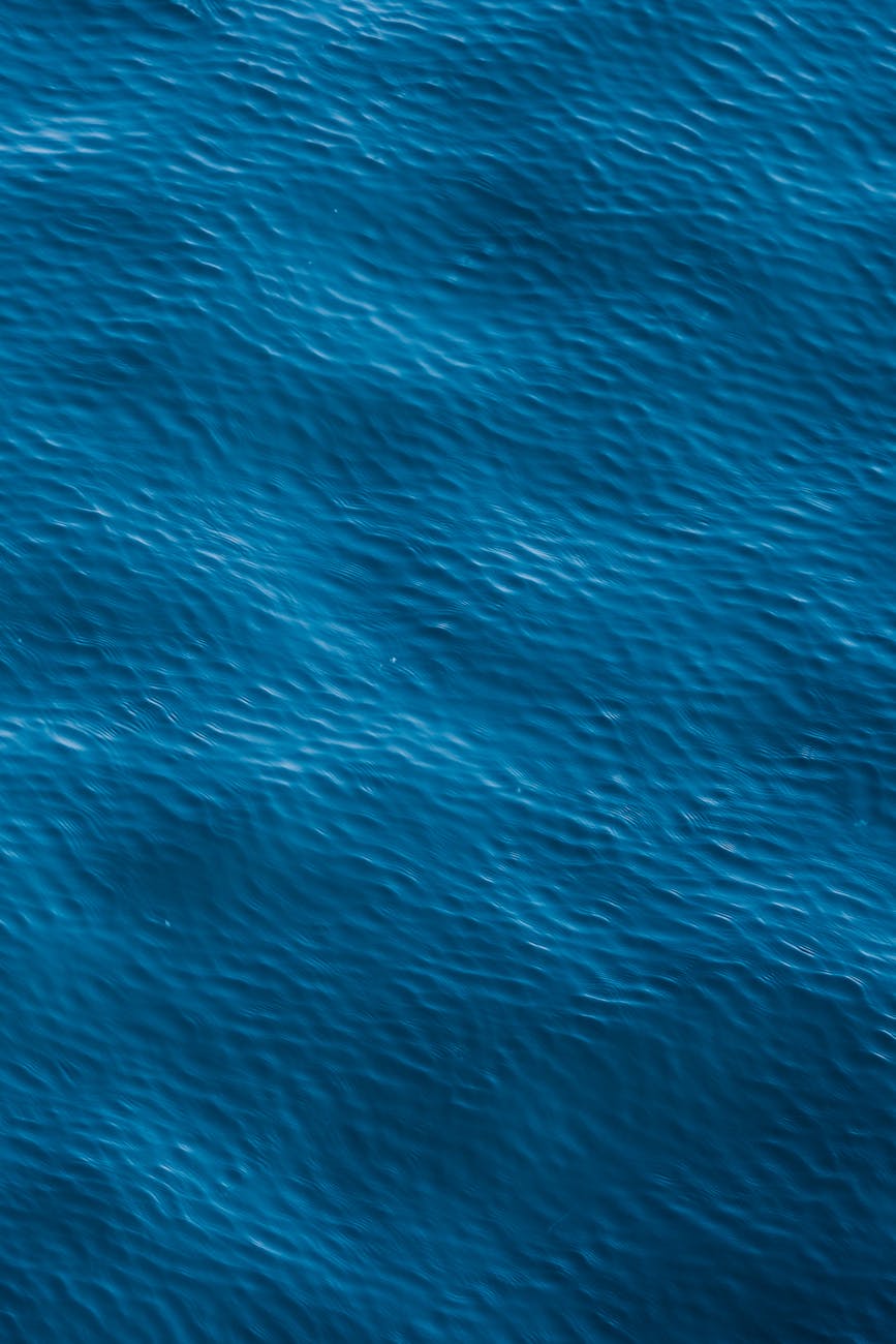 Serene aerial view of vibrant blue ocean waves forming abstract patterns.