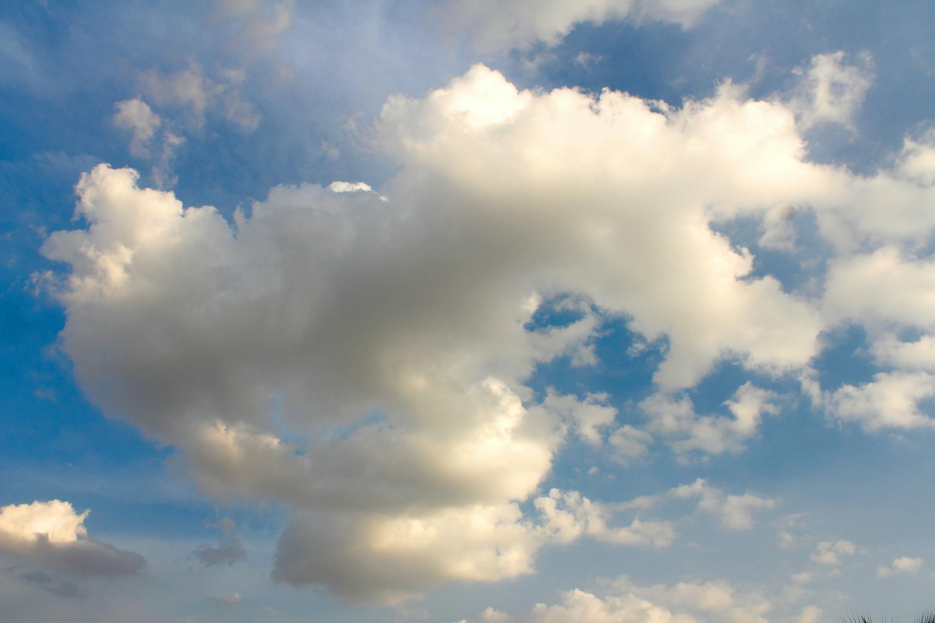 A serene view of cumulus clouds floating against a vivid blue sky, depicting fair weather.