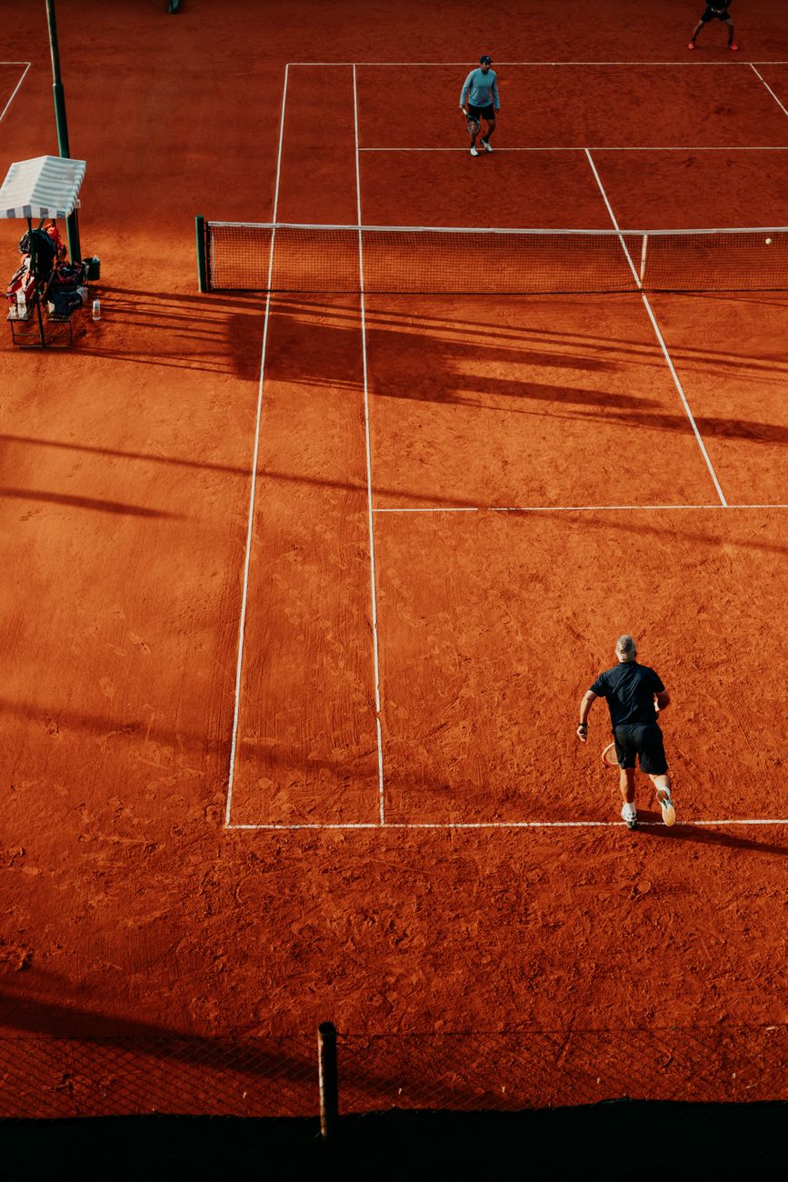 Aerial view of players in action on a clay tennis court in Buenos Aires, Argentina.