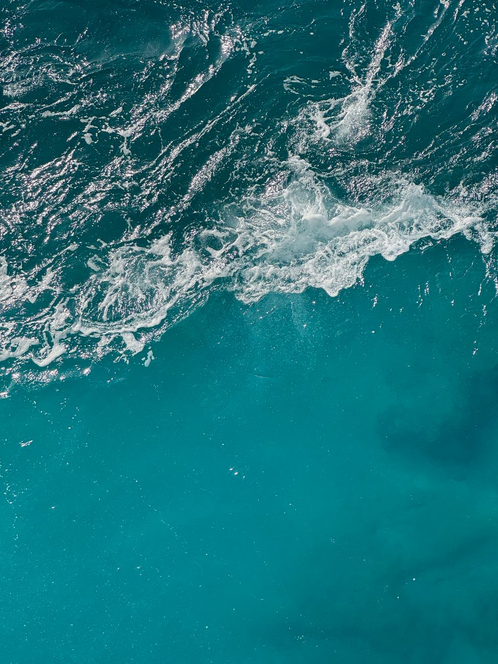 Stunning aerial view of turquoise ocean waves crashing, showcasing Malta's natural beauty.