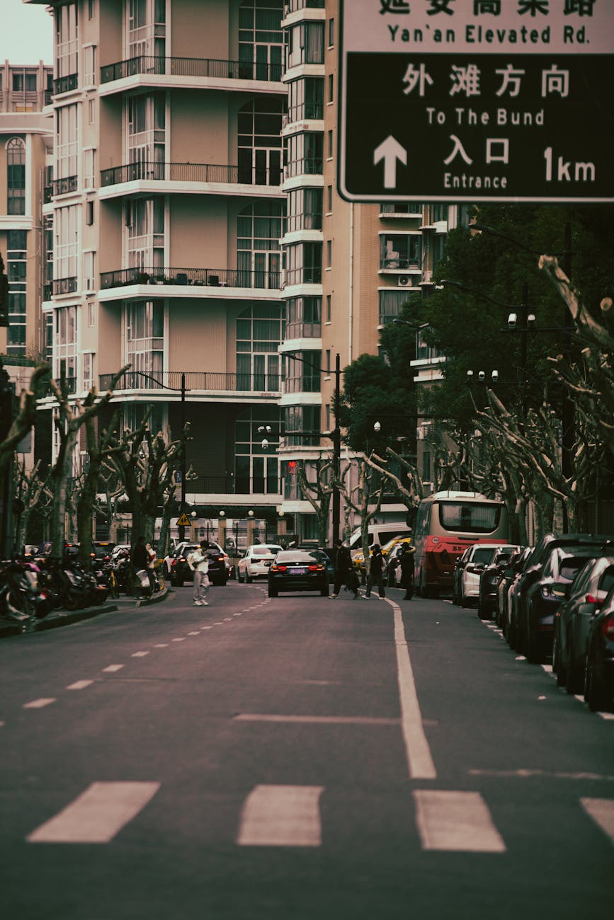 Urban street view with modern buildings and vehicles, showcasing city life in daylight.