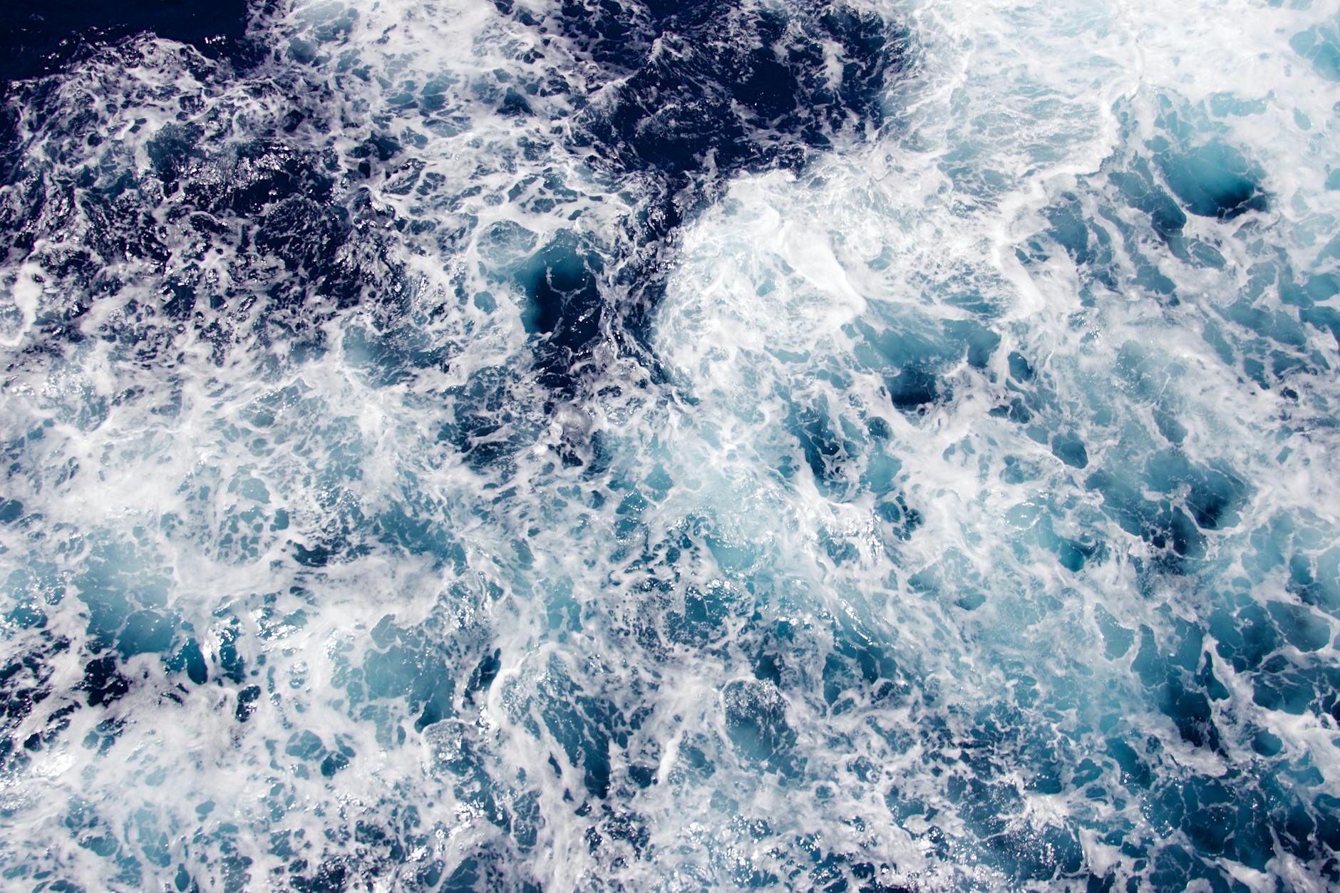 A dramatic view of swirling ocean waves captured from above, showcasing the beauty of maritime motion.