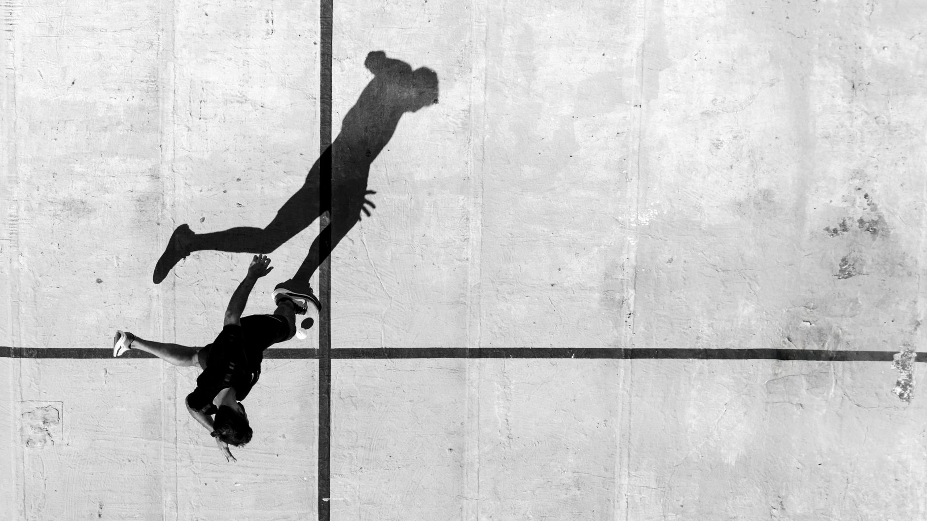 Aerial view of player and shadow on urban court in Buenos Aires.