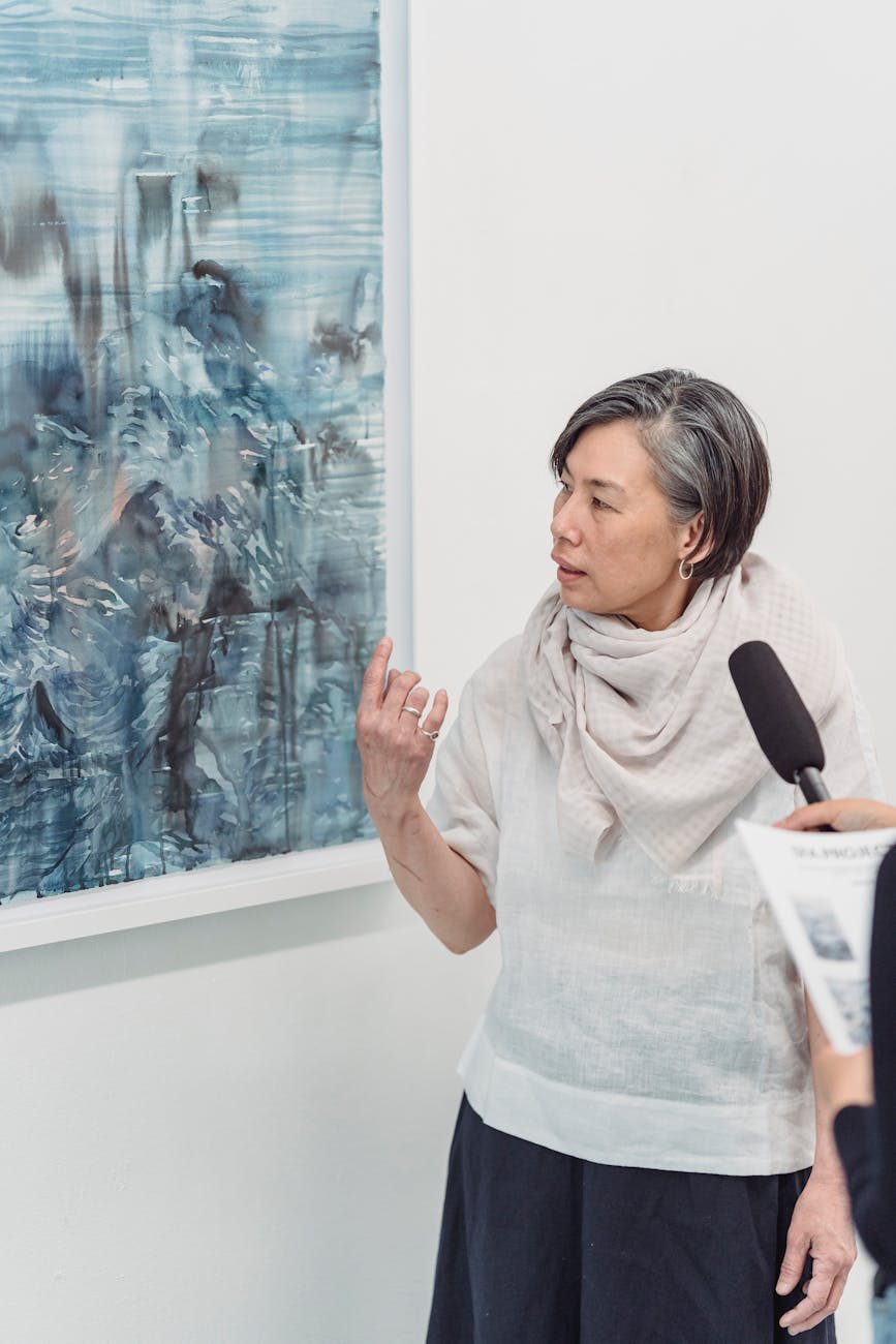 An artist speaks about her abstract painting during a gallery interview.