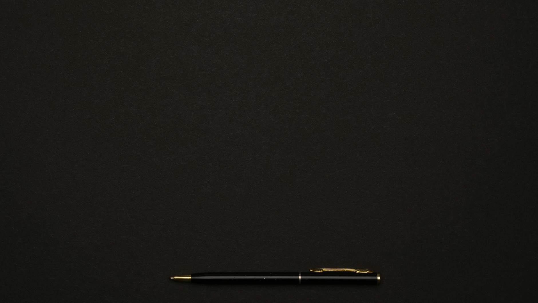 A sleek black pen placed on a minimalist dark background, perfect for professional presentations.
