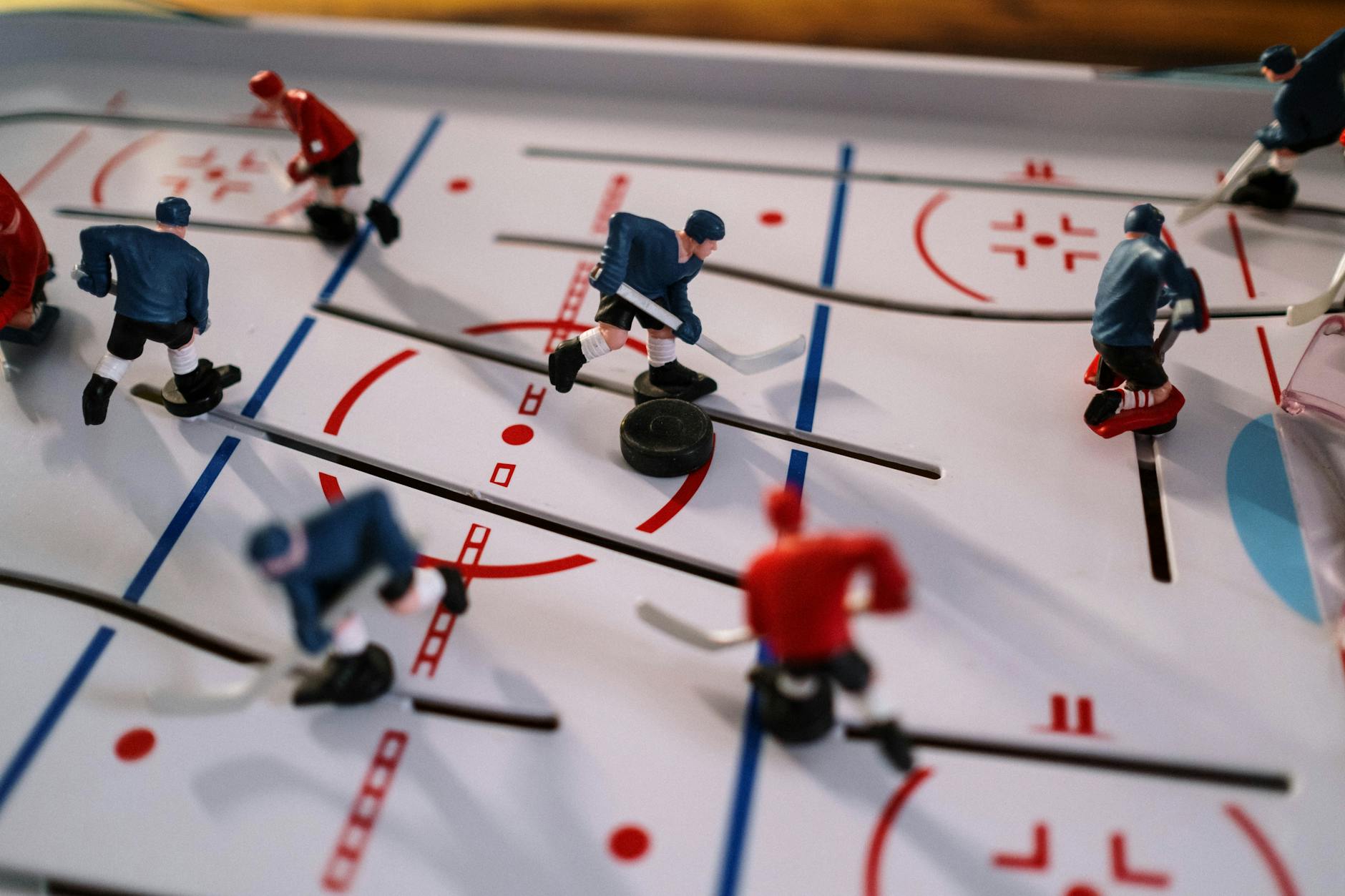 Closeup on a table hockey game showcasing figurines in motion on the playing field.