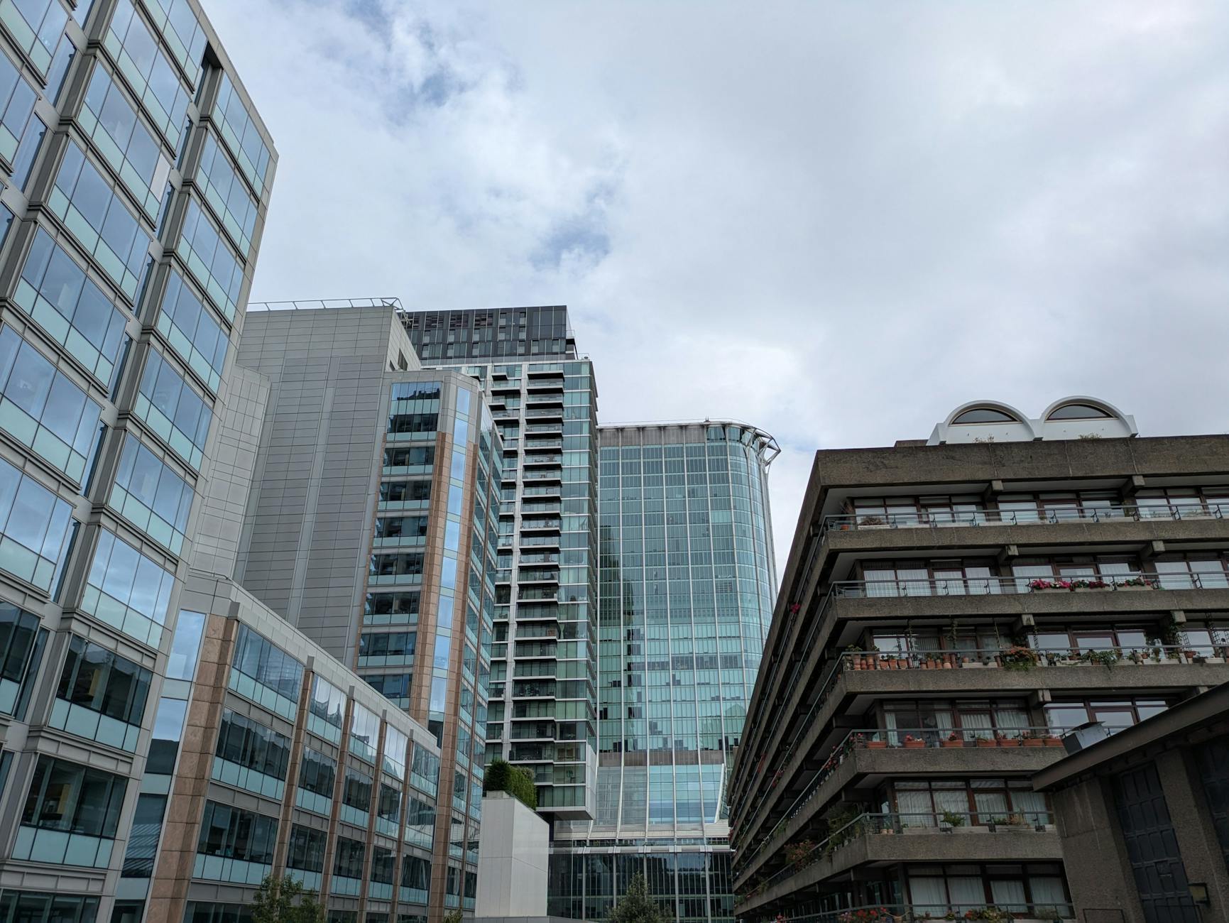 Skyline view of modern urban architecture with high-rise buildings under a cloudy sky.