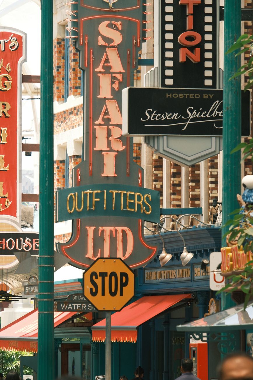 Street shot featuring vintage-style signs and a stop sign in a bustling urban area.