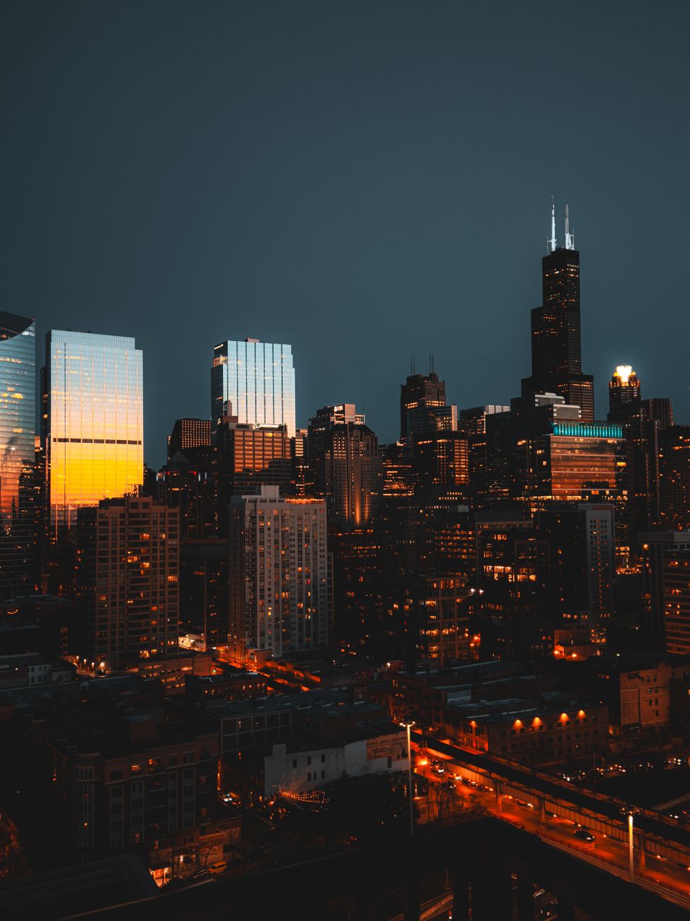 Stunning view of Chicago's illuminated skyline featuring the Willis Tower during twilight.