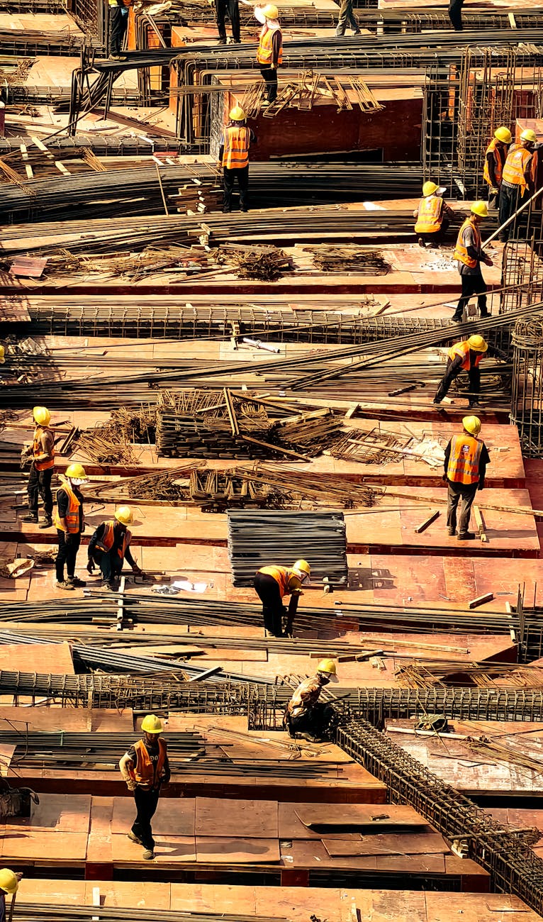 Workers in safety gear actively working on a large construction site.
