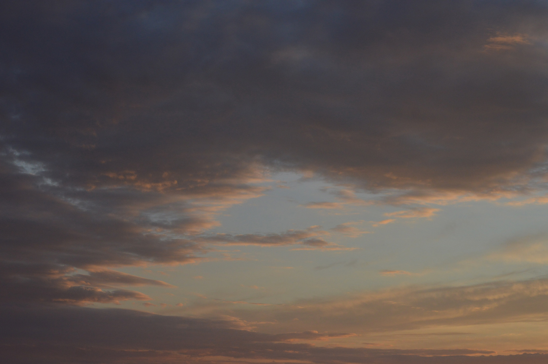 Dramatic twilight cloudscape with warm hues and soft lighting, creating a tranquil evening atmosphere.