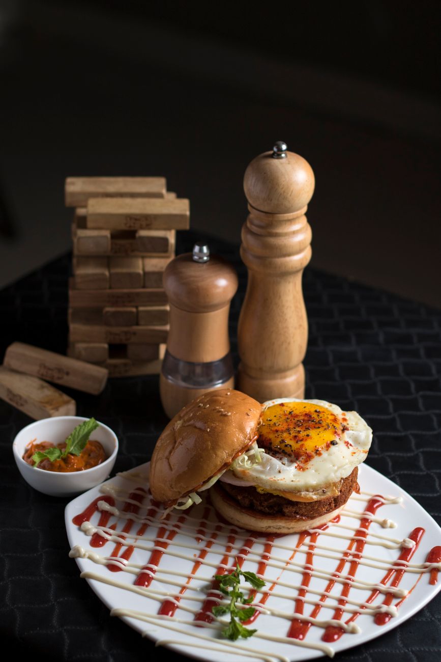Mouth-watering burger with fried egg and gourmet sauce, ideal for lunch or dinner.
