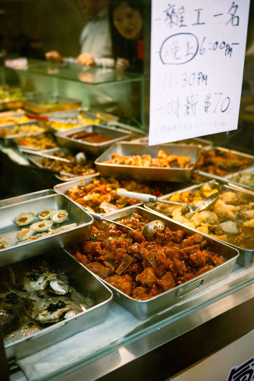 Vibrant display of Asian street food with various dishes in a bustling market setting.