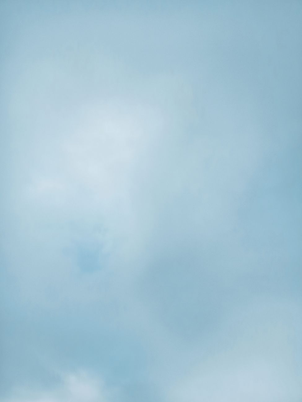 An expansive view of a clear blue sky with gentle wispy clouds creating a peaceful atmosphere.