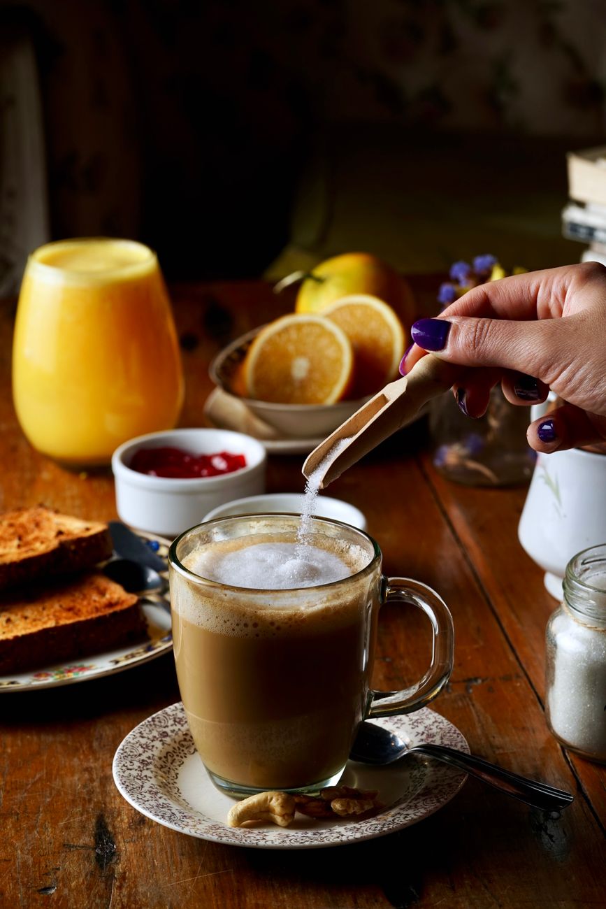 Inviting breakfast spread with cappuccino, orange juice, and toast on a rustic table.