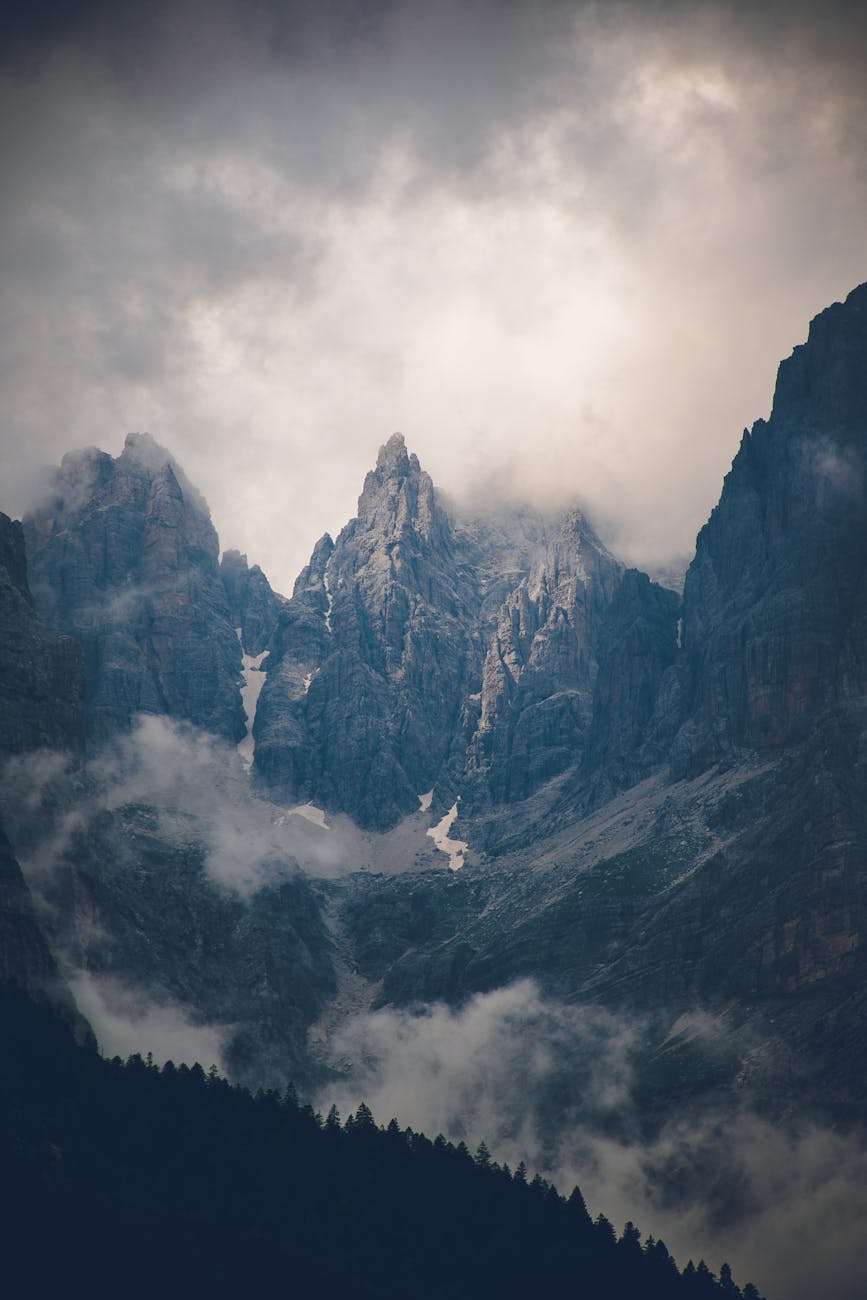 Scenic view of dramatic mountain peaks shrouded in clouds.