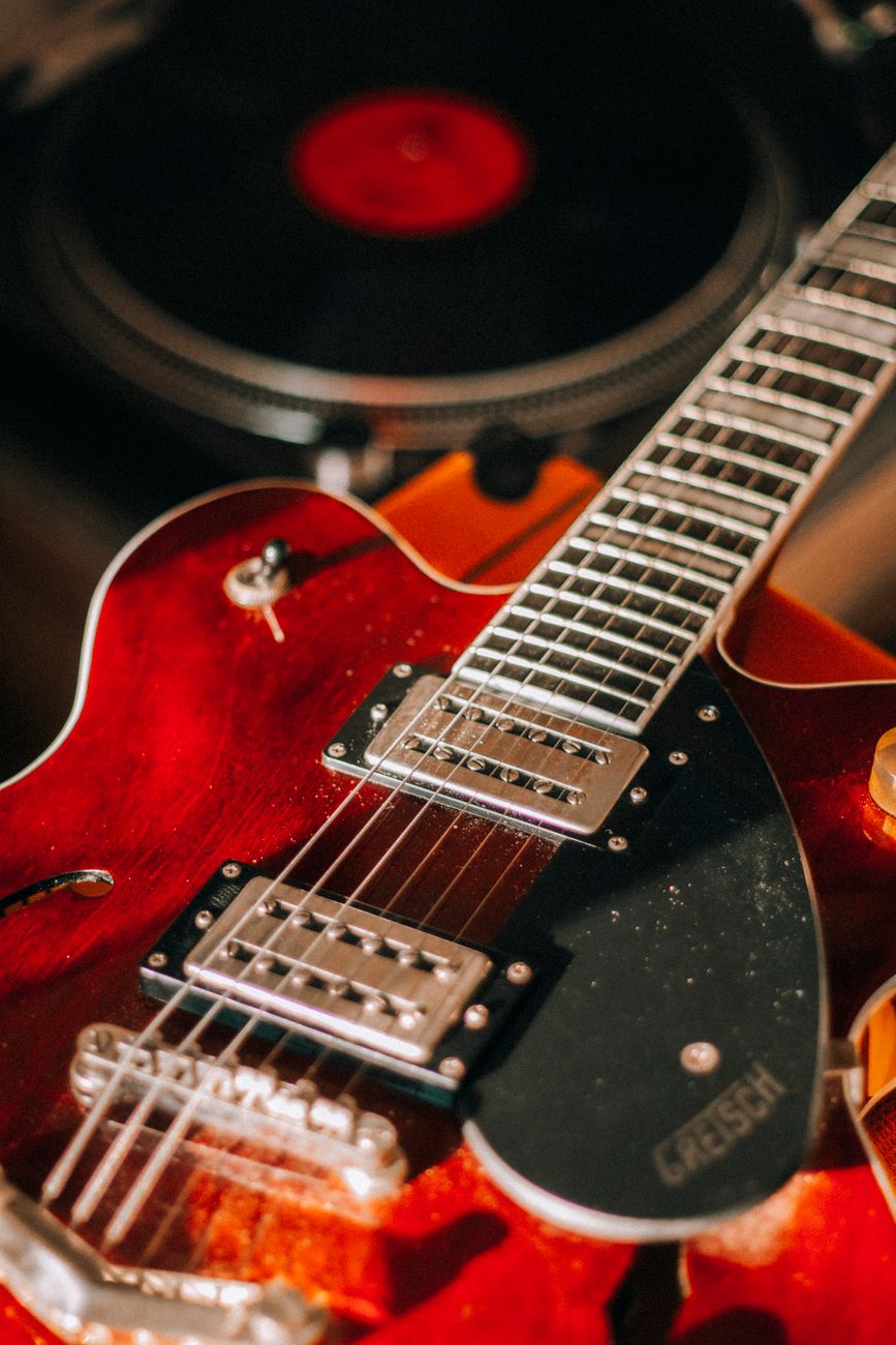Detailed image of an electric guitar fretboard with focus on the strings and body.
