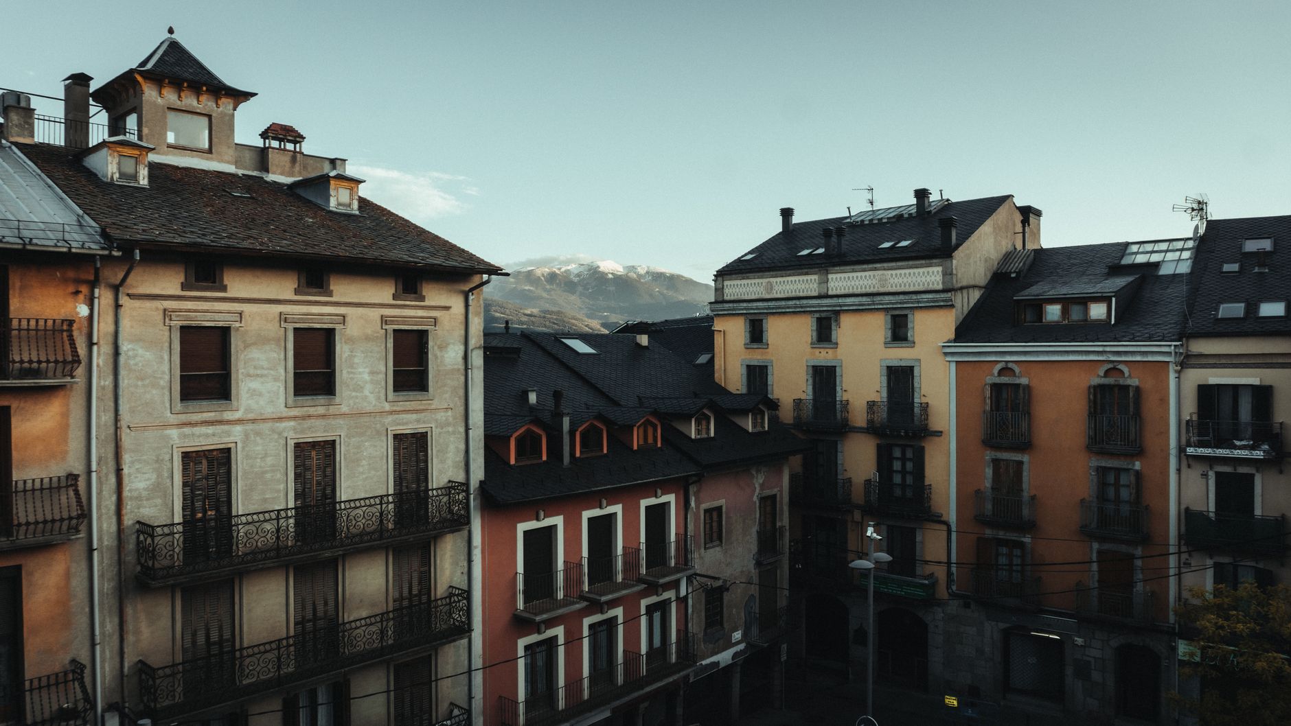 Scenic view of European city architecture with mountains in the background, captured during daylight.