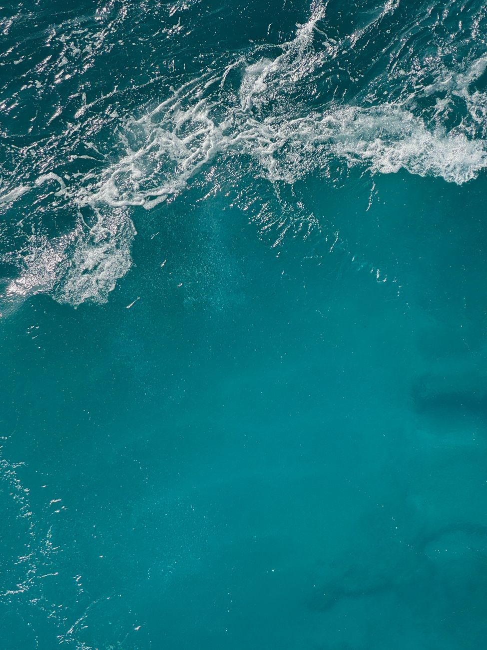 Stunning aerial capture of the clear blue waves in the Mediterranean Sea near Malta, highlighting nature's beauty.